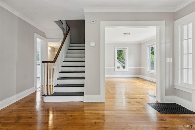 staircase featuring crown molding and hardwood / wood-style floors