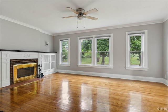 unfurnished living room with ornamental molding, a fireplace, light hardwood / wood-style floors, and a healthy amount of sunlight