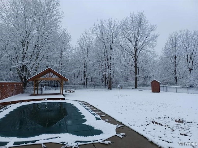 yard layered in snow featuring a shed and a gazebo