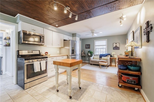 kitchen featuring appliances with stainless steel finishes, white cabinets, ceiling fan, wood ceiling, and track lighting