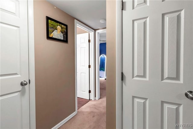 hallway with light colored carpet and baseboards