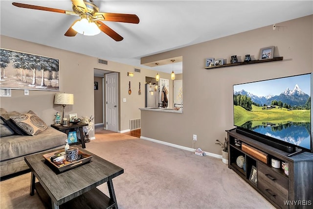 carpeted living room with visible vents, ceiling fan, and baseboards