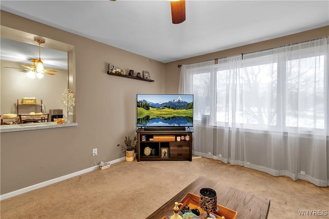 living room featuring baseboards, a ceiling fan, and carpet floors