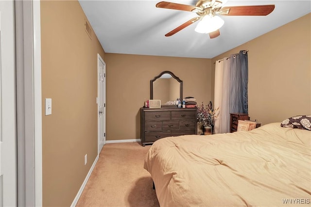 bedroom with a ceiling fan, visible vents, light colored carpet, and baseboards