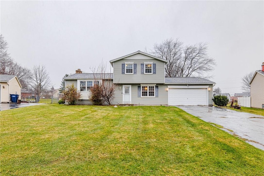 split level home with a garage and a front lawn