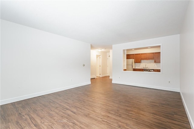 unfurnished living room with dark wood-type flooring and sink