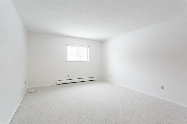 empty room featuring a baseboard radiator, carpet floors, and a textured ceiling