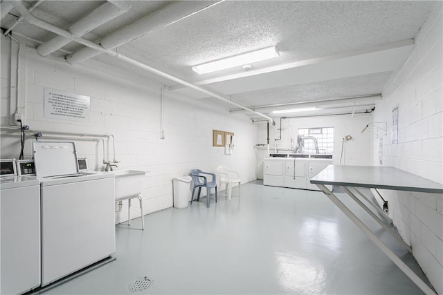 washroom with sink, independent washer and dryer, and a textured ceiling