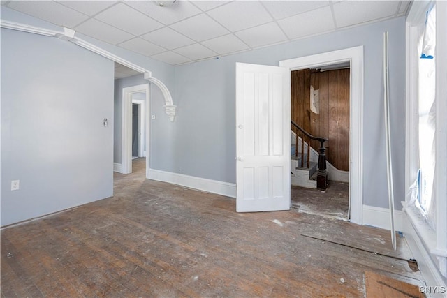 empty room with a paneled ceiling and wood-type flooring