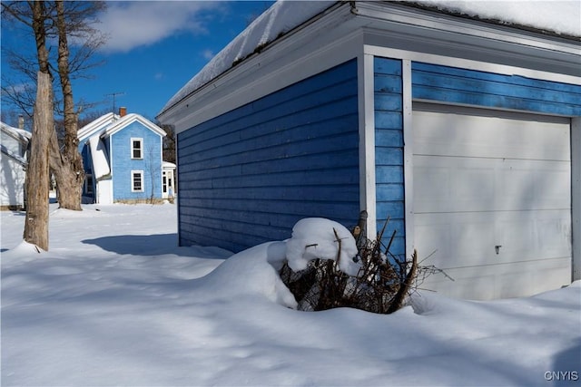 view of snow covered exterior with a garage