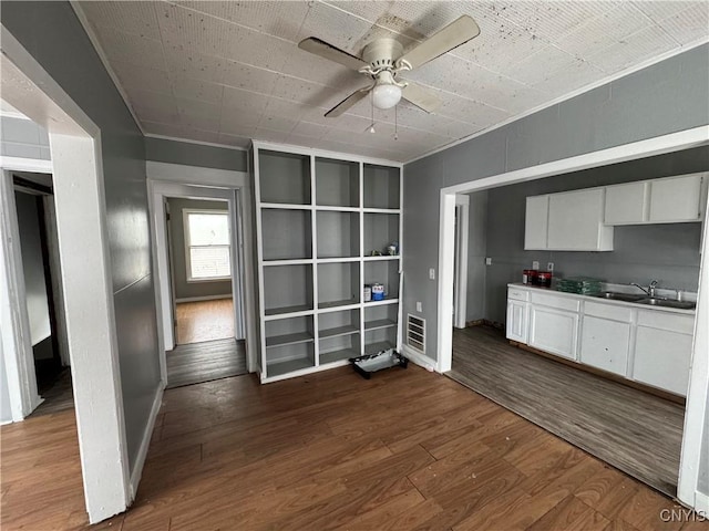 kitchen featuring dark wood-type flooring, ceiling fan, sink, and white cabinets