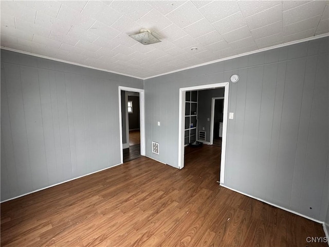 empty room featuring hardwood / wood-style flooring and crown molding