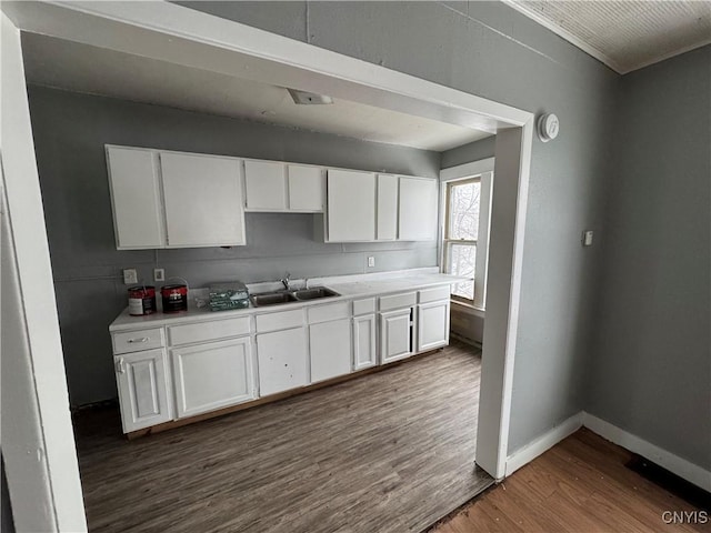 kitchen with dark hardwood / wood-style flooring, sink, and white cabinets