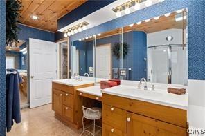 bathroom featuring wood ceiling, vanity, and a shower with door