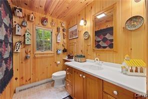 bathroom featuring vanity, wood ceiling, toilet, and wood walls