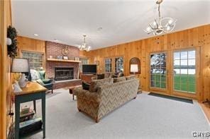 living room with a chandelier and wood walls