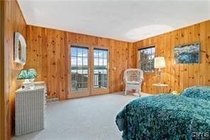 bedroom featuring carpet floors, access to outside, and wood walls