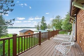 wooden deck with a lawn and a water view