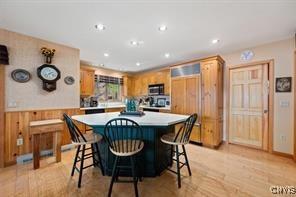 kitchen with a kitchen bar, light hardwood / wood-style flooring, wooden walls, and a kitchen island