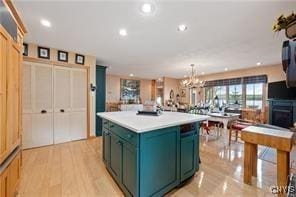 kitchen featuring hanging light fixtures, a center island, a chandelier, and light wood-type flooring