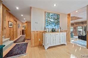 interior space with light hardwood / wood-style floors and wood walls