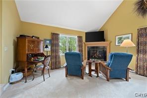 living area featuring lofted ceiling and light colored carpet