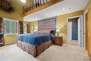 bedroom with a high ceiling and carpet