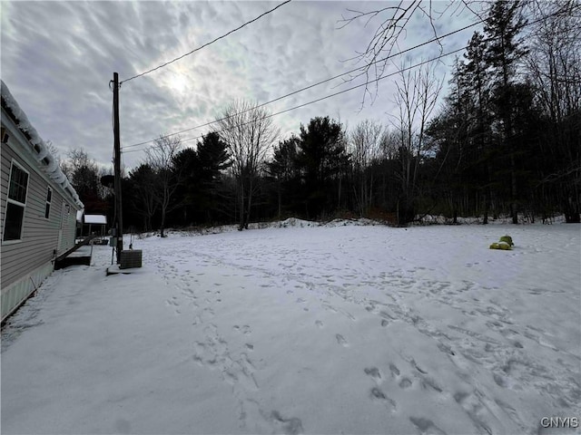 yard covered in snow featuring central AC unit