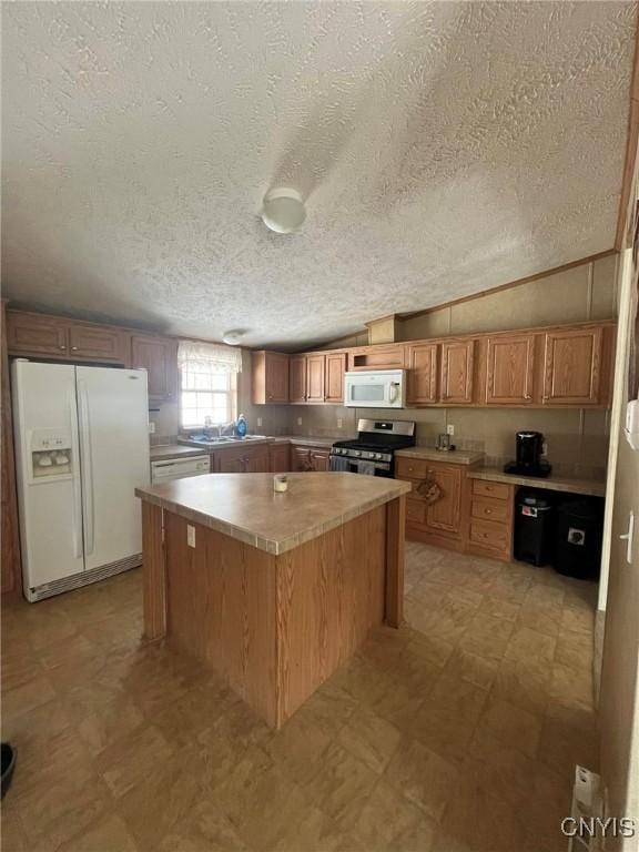 kitchen with a kitchen island, lofted ceiling, sink, and white appliances