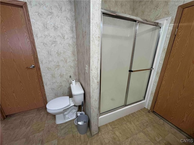 bathroom featuring walk in shower and toilet