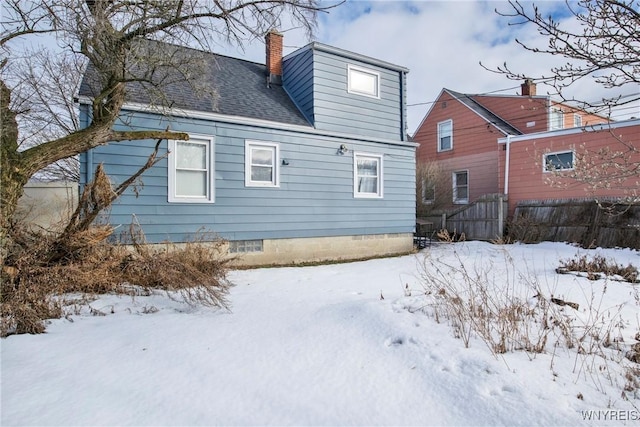 view of snow covered rear of property