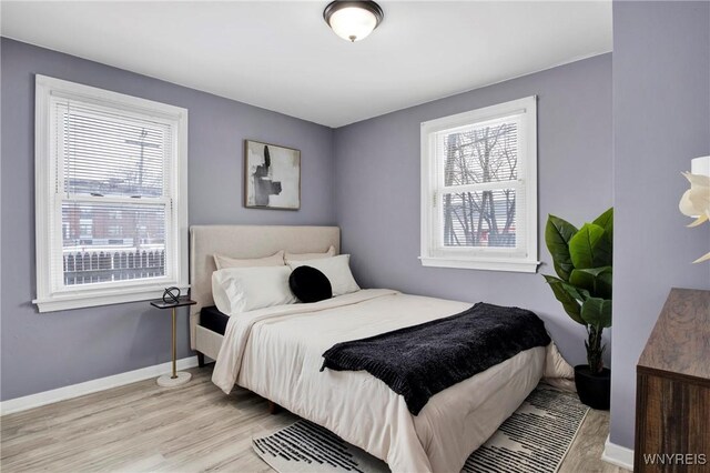 bedroom with multiple windows and light hardwood / wood-style floors