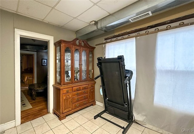 workout room featuring light tile patterned floors, visible vents, and a drop ceiling