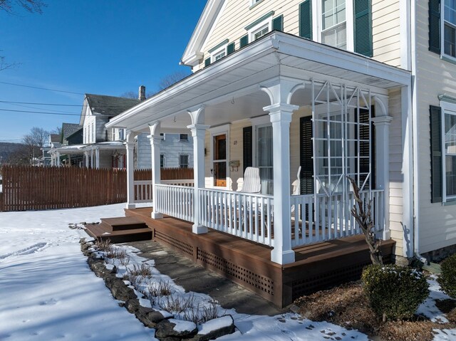 snow covered deck with a porch