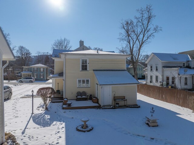 view of snow covered rear of property