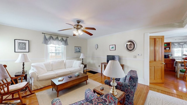 living room featuring crown molding, ceiling fan, light hardwood / wood-style floors, and a wealth of natural light