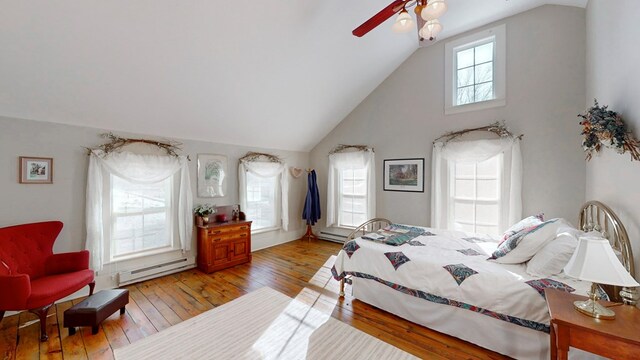 bedroom with ceiling fan, high vaulted ceiling, light wood-type flooring, and baseboard heating