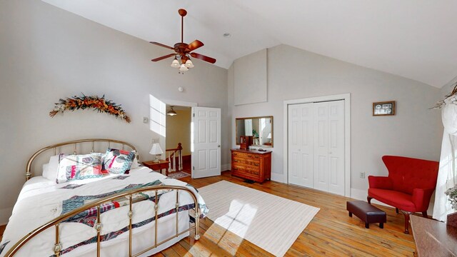 bedroom with high vaulted ceiling, light hardwood / wood-style floors, a closet, and ceiling fan