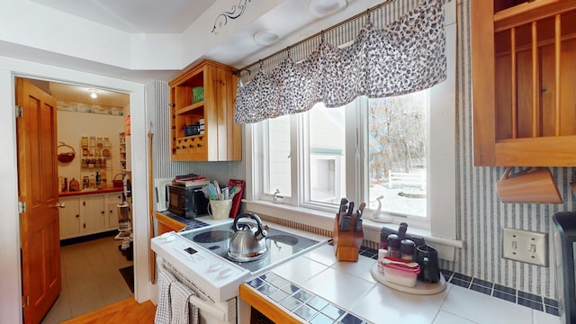 kitchen featuring tile counters and white range with electric stovetop