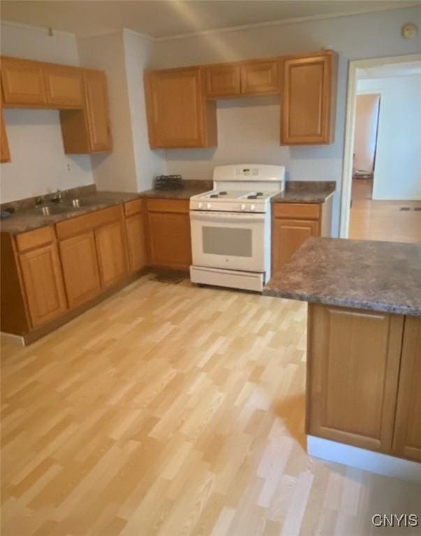 kitchen featuring sink, kitchen peninsula, light wood-type flooring, and gas range gas stove