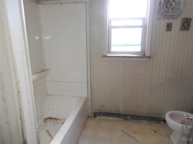 bathroom featuring a tub and toilet