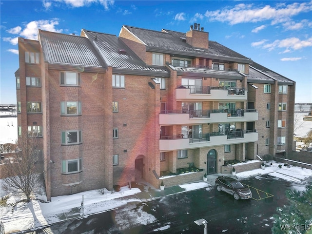 snow covered property with a wall mounted air conditioner