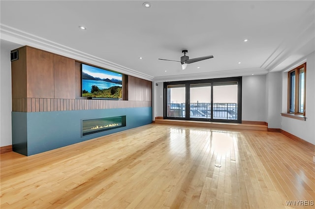 unfurnished living room with crown molding, ceiling fan, and light wood-type flooring