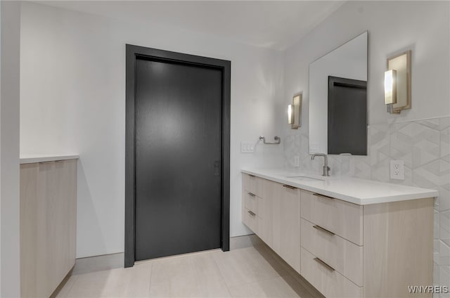 bathroom featuring vanity, tile patterned flooring, and backsplash