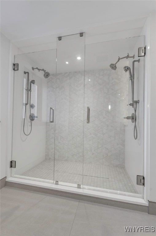 bathroom with a shower with door and tile patterned floors