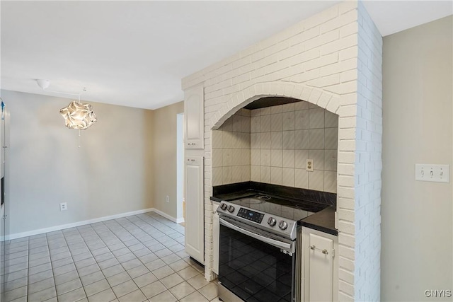 kitchen with tasteful backsplash, hanging light fixtures, stainless steel electric range, and light tile patterned floors