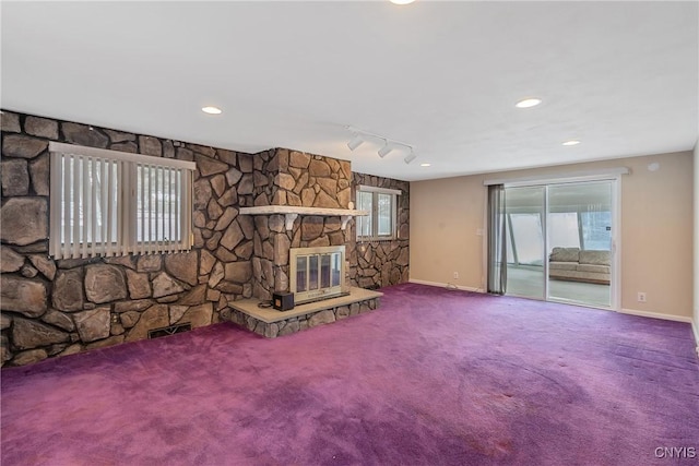 unfurnished living room with rail lighting, carpet floors, and a fireplace