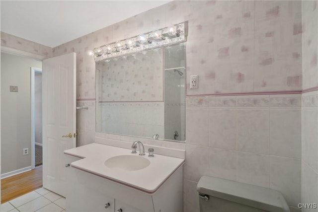 bathroom featuring vanity, tile walls, tile patterned floors, and toilet