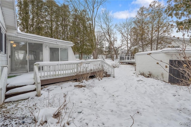 snowy yard featuring a wooden deck