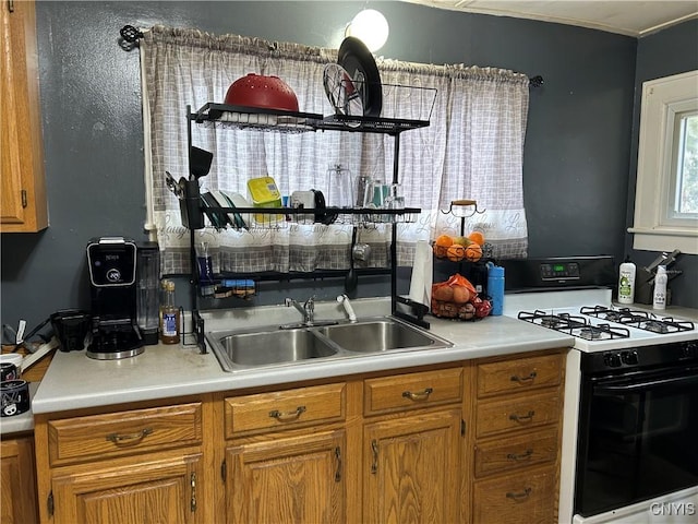 kitchen featuring brown cabinetry, gas stove, and light countertops